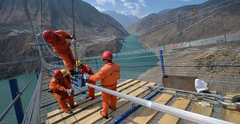 operai cinesi al lavoro sul ponte Xingkang