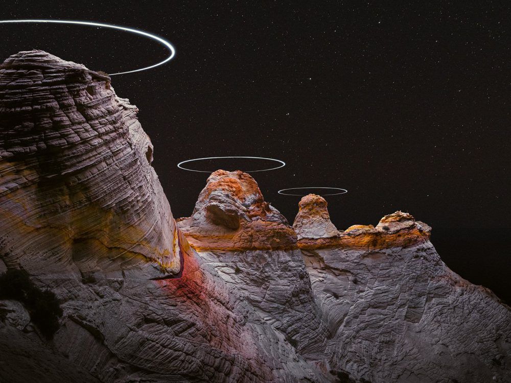 immagine di drone with led lights creates halos over rock formations